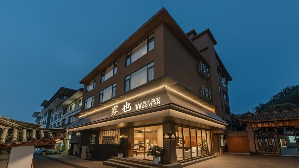 a building with a sign on the front of it at Wuye WOO YEAH Tangchi Hotel in Emeishan City