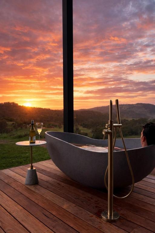 a bath tub sitting on a deck with a sunset at Silk & Oak in Darlington