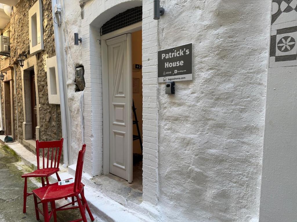 two red chairs sitting in front of a house at Patrick's Traditional Home in Pyrgi