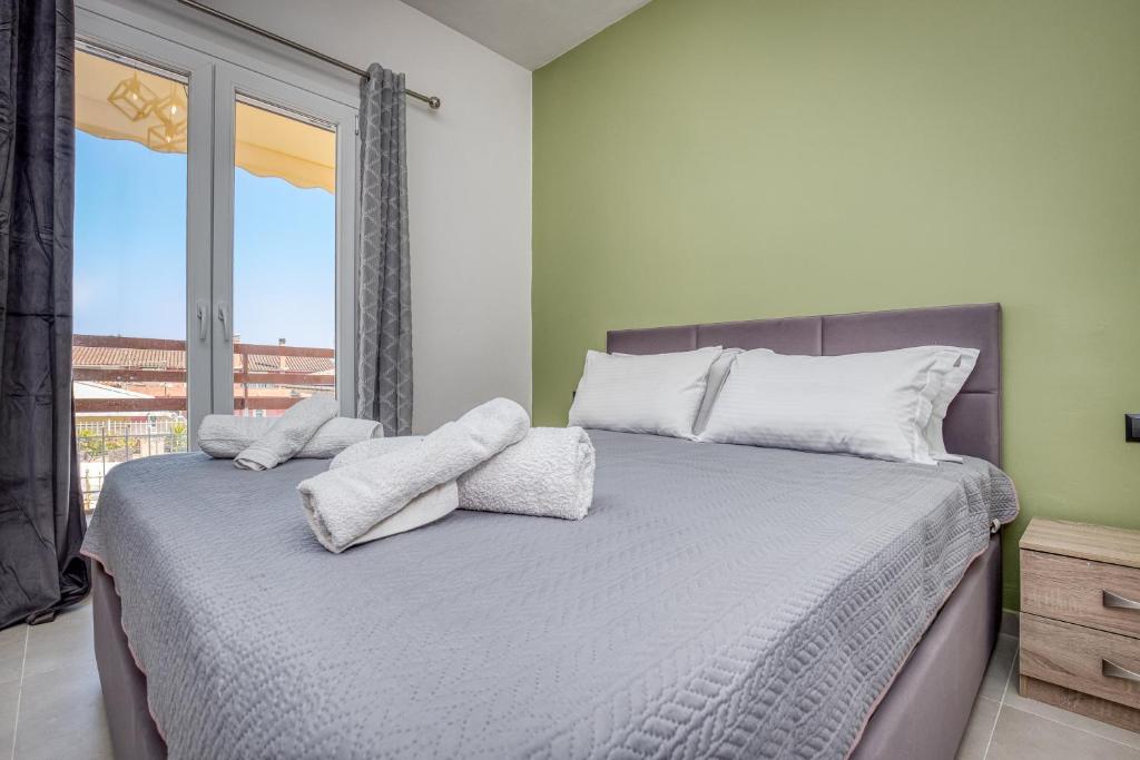a bedroom with a bed with white pillows and a window at Rubick solari studio in Mantoúkion
