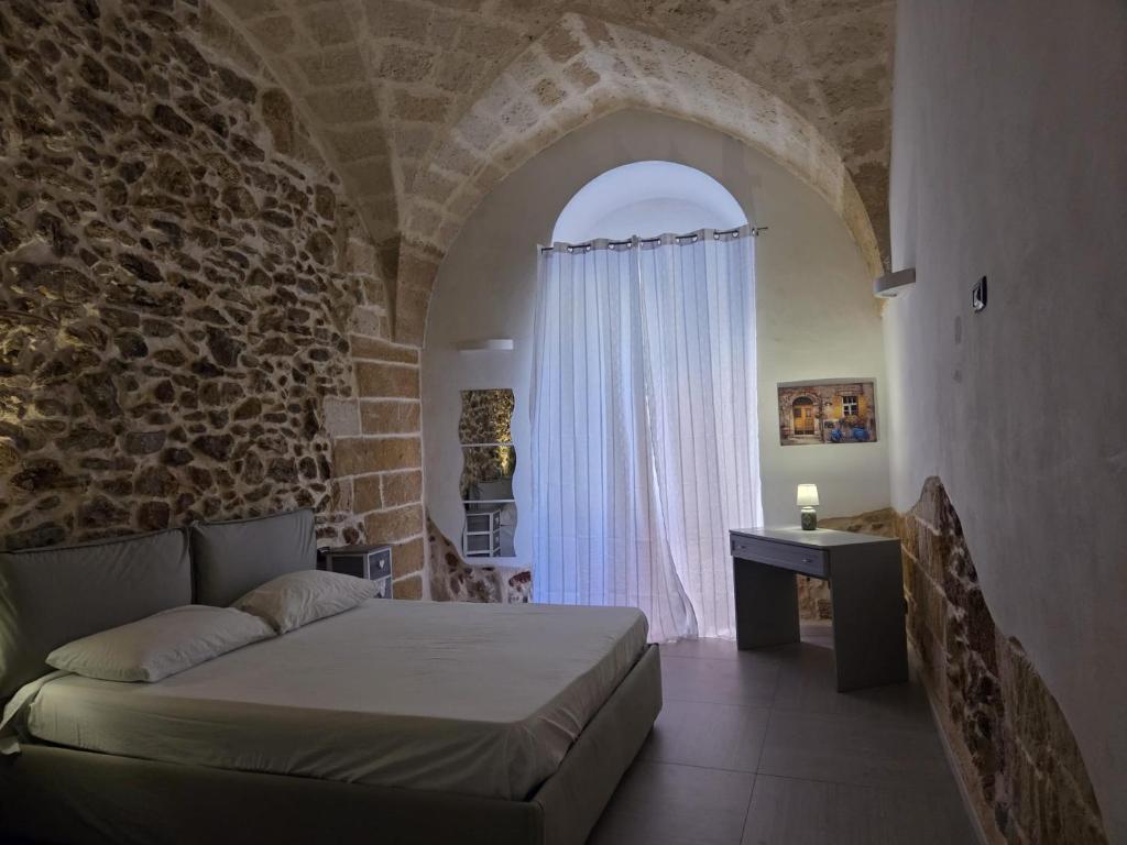 a bedroom with a bed and a stone wall at Casa vacanze G&G in Brindisi