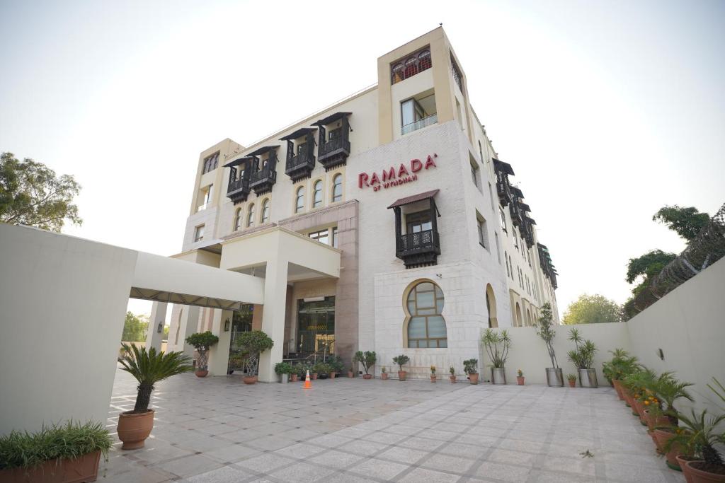 a large white building with a courtyard in front of it at Ramada by Wyndham Islamabad in Islamabad