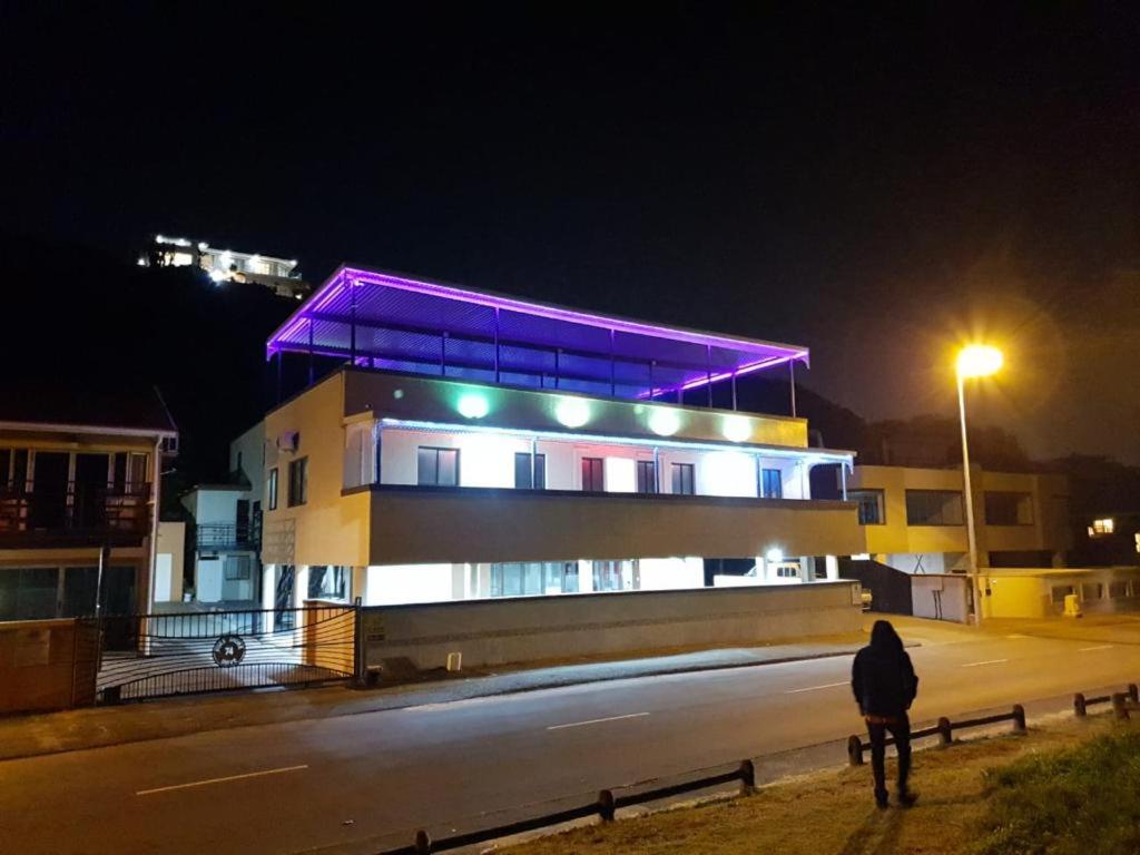 a person standing in front of a building at night at Palmnut Lodge in Durban