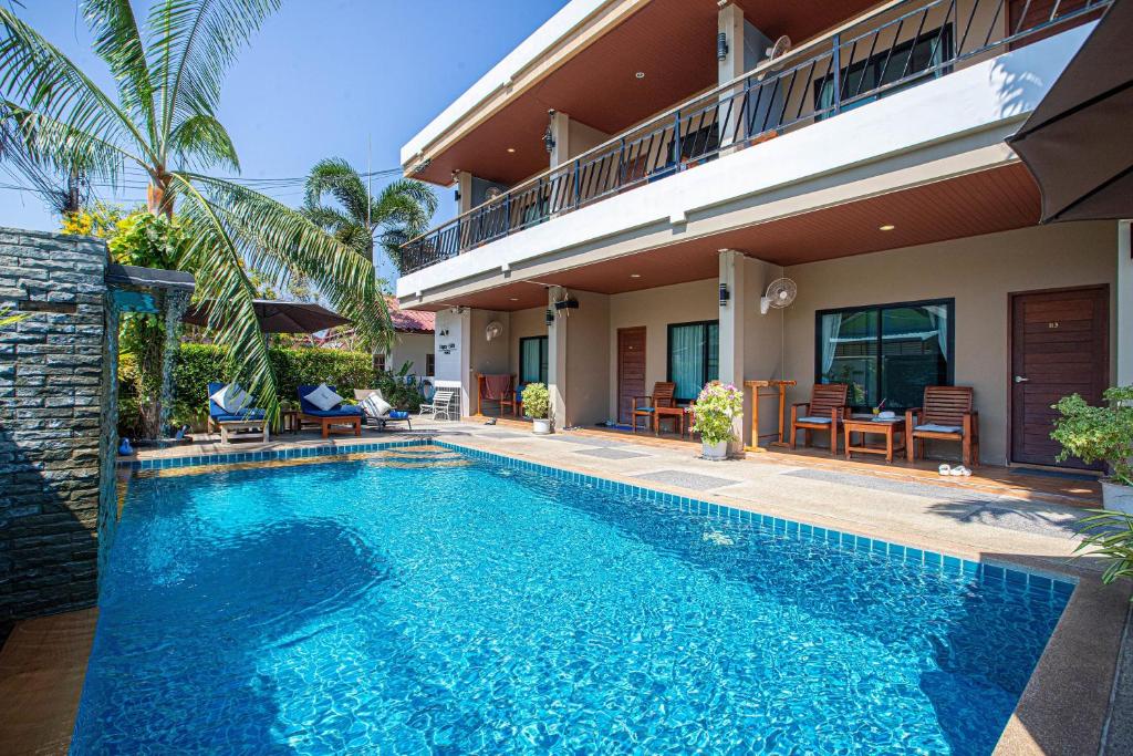a swimming pool in front of a house at Happy Eight Resort in Nai Harn Beach