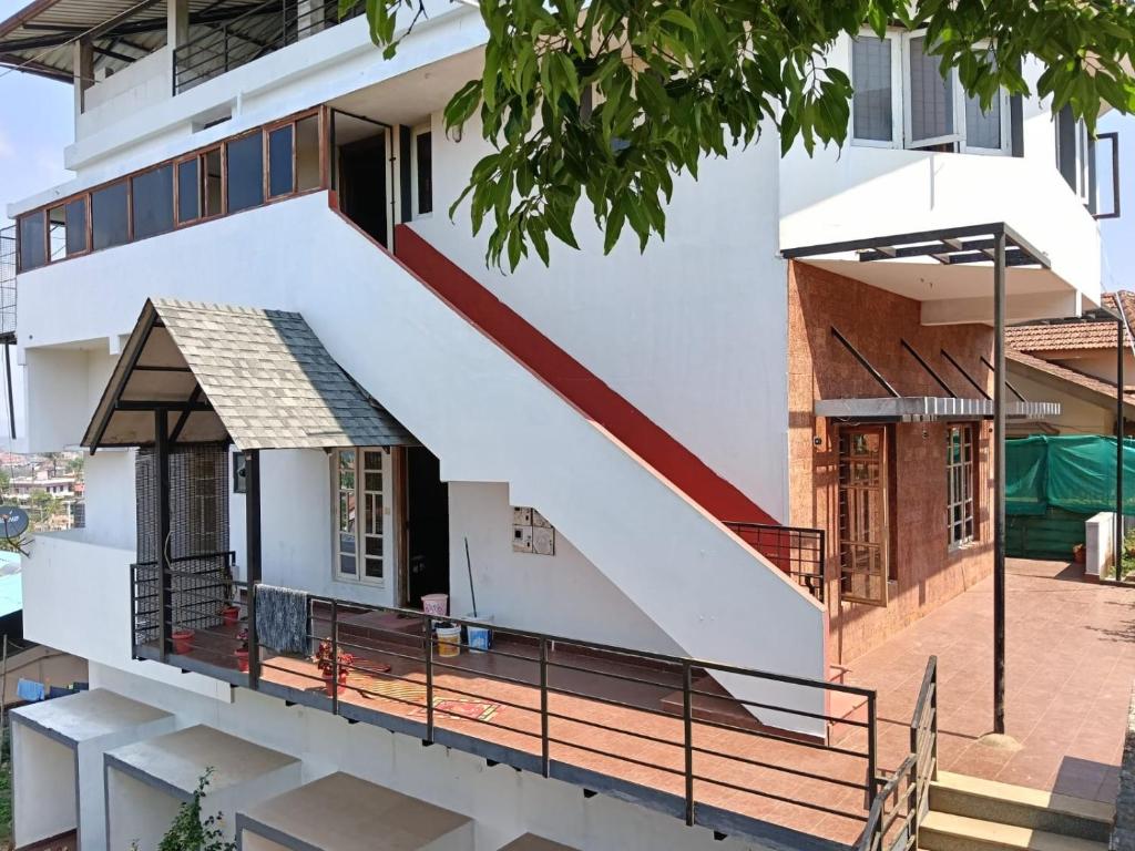 a house with a staircase to the second floor at Coorg rest house in Madikeri