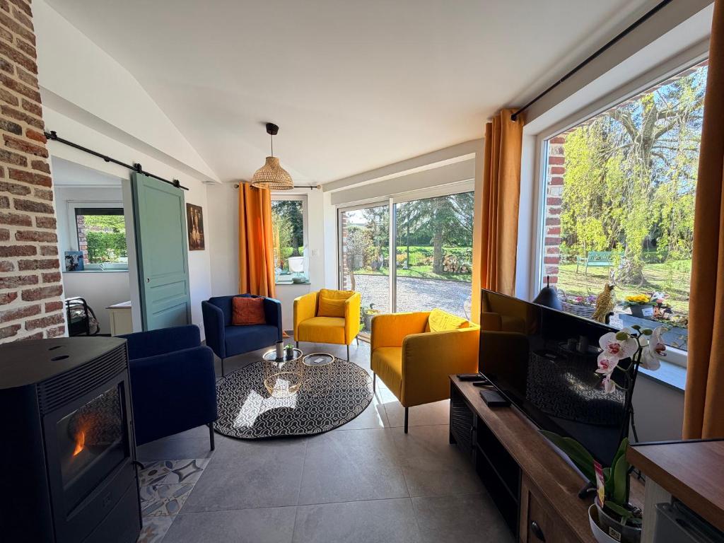 a living room with a fireplace and a tv at Au bord de l'étang in Saint-Aubin