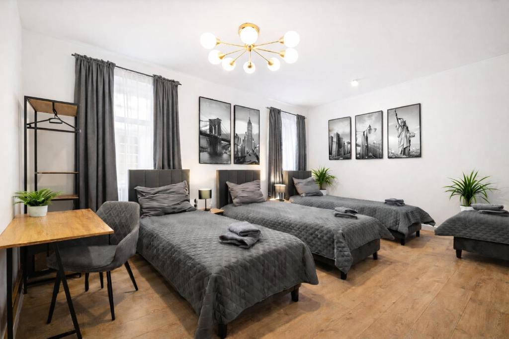 a living room with four beds and a table at Platinum Prestige Residence in Rybnik