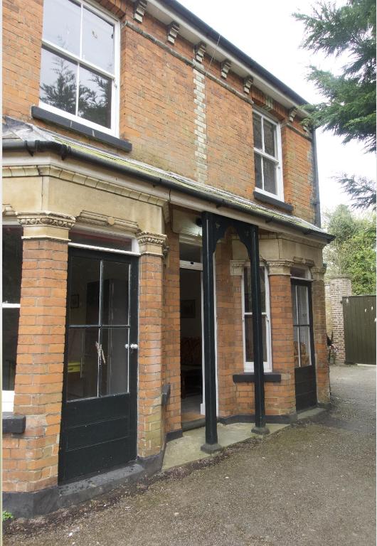 an old brick building with a black door at St Marys Cottages 1 in Dover