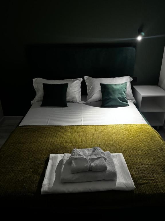 a bedroom with a large white bed with a yellow blanket at Qonys Hostel in Atyrau