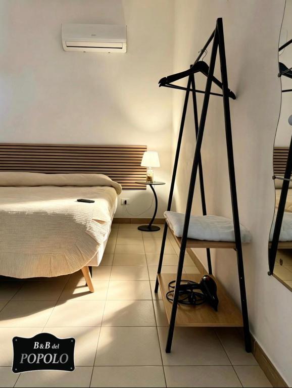 a bedroom with a bed and a chair in it at B&B Del Popolo in Torre Chianca