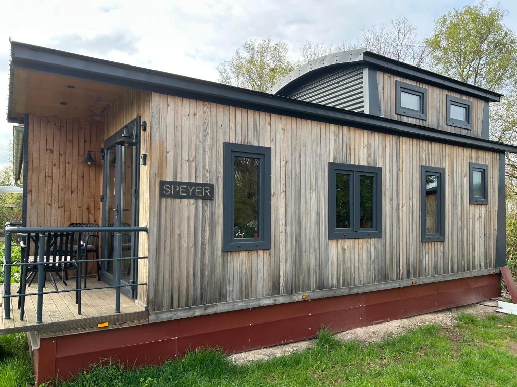 a large wooden house with a round roof at Tiny Haus roter Wagen in Langenselbold