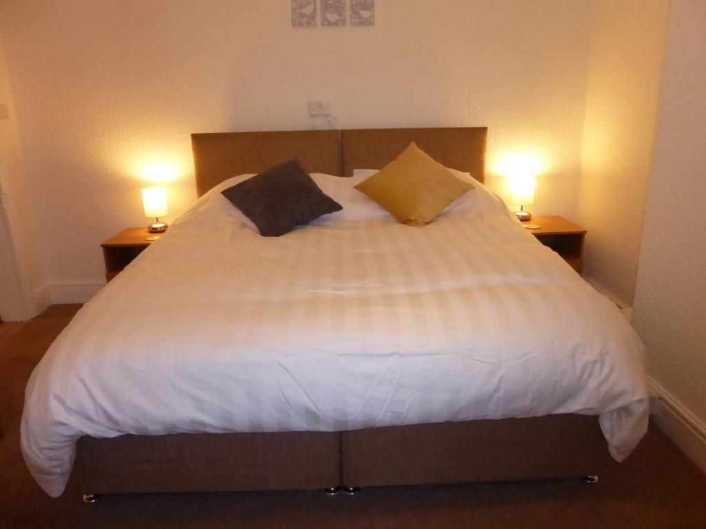 a bedroom with a large white bed with two lamps at Mersey View, Two Bedroom Apartment, Liverpool in Waterloo