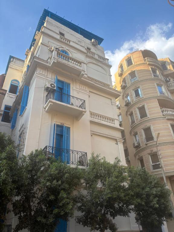 a tall white building with blue balconies next to a building at Colour Holidays in Cairo