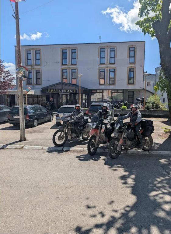 Drei Personen auf Motorrädern parkten auf einem Parkplatz. in der Unterkunft Hotel Split in Glamoč