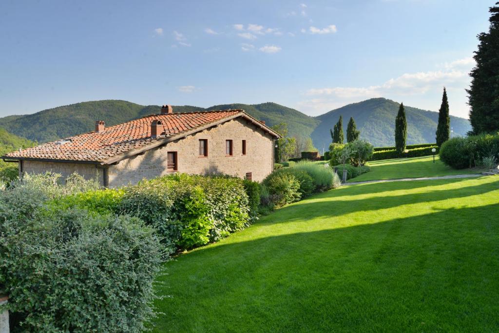 a house in the middle of a green yard at Agriturismo Il Colle in Poggio Alla Croce
