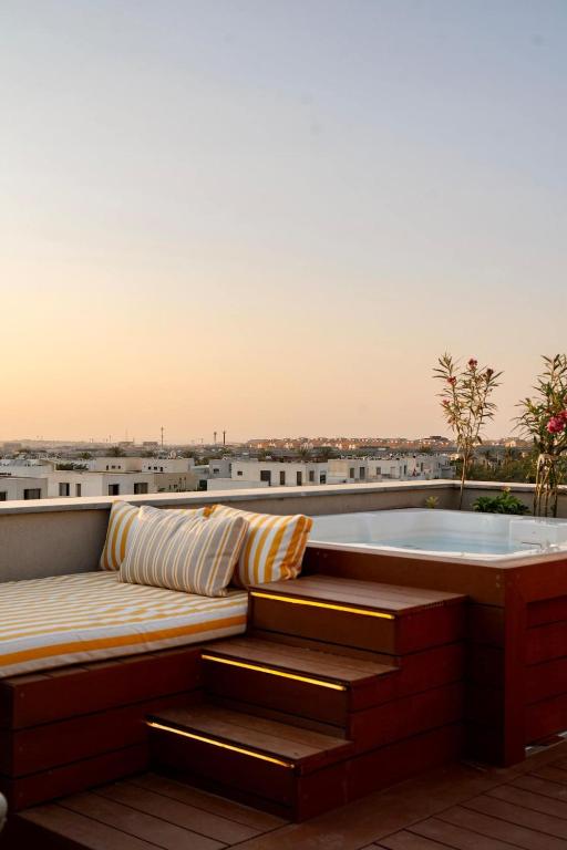 a bath tub sitting on top of a roof at VELORA - Sodic Penthouse with jacuzzi & big terrace over New Cairo view in New cairo