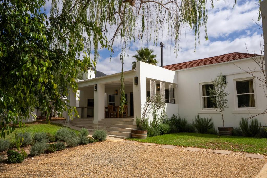 a white house with a tree at Hoof House in Riebeek-Kasteel