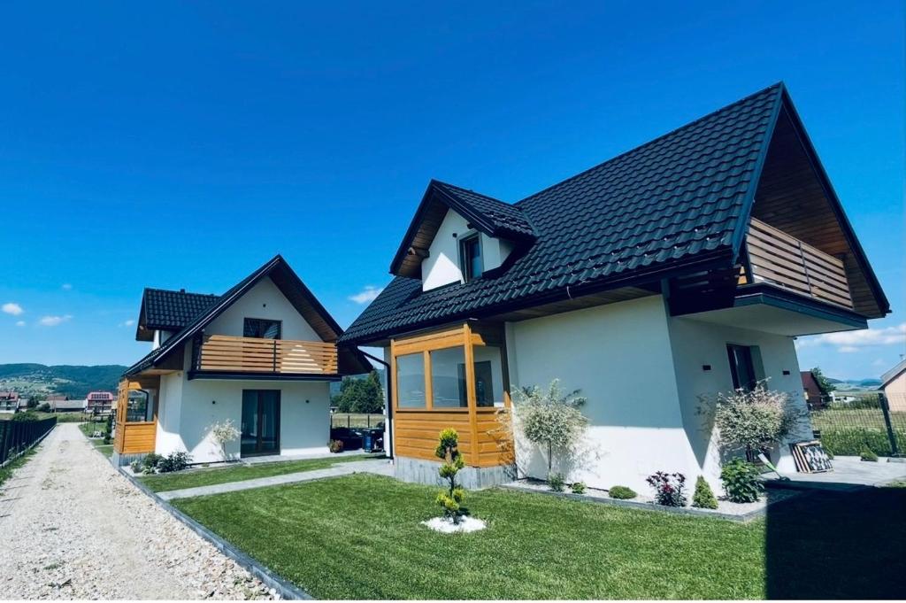 a house with a black roof at Domki Dolina Dunajca-Balia, Jacuzzi, Spa Nad Jeziorem in Frydman