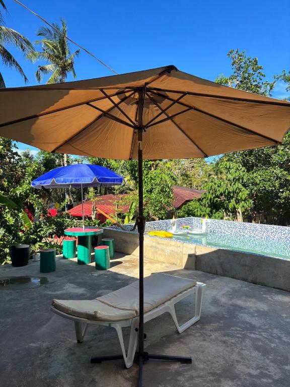 a chair and an umbrella next to a pool at Private Villa in Masbate