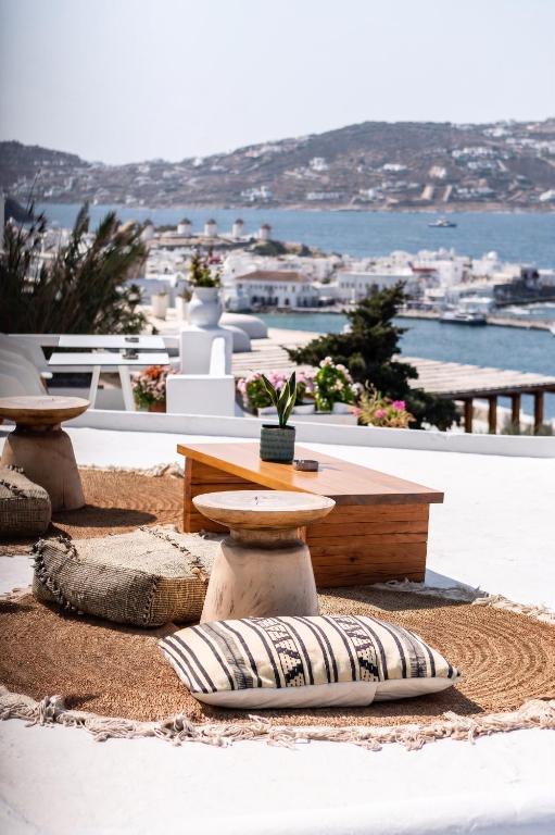 a table and pillows on the ground with a view of the ocean at Hotel Madalena in Mikonos