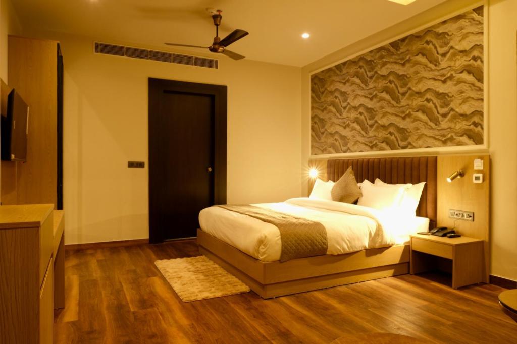 a bedroom with a bed and a ceiling fan at Red Sapphire Royale in Morādābād