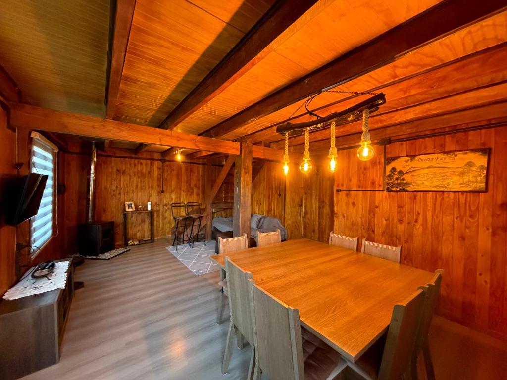 a dining room with a large wooden table and chairs at Cabaña Amancay Fuy in Puerto Fuy