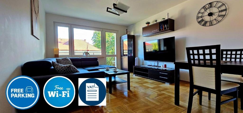 a living room with a couch and a table and a tv at Apartament Gdynia Babie Doły in Gdynia