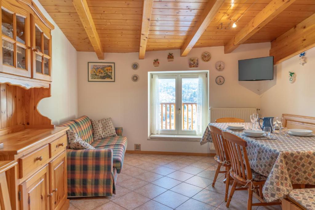 a living room with a table and a couch at Leonardo al Maso Fovo in Andalo