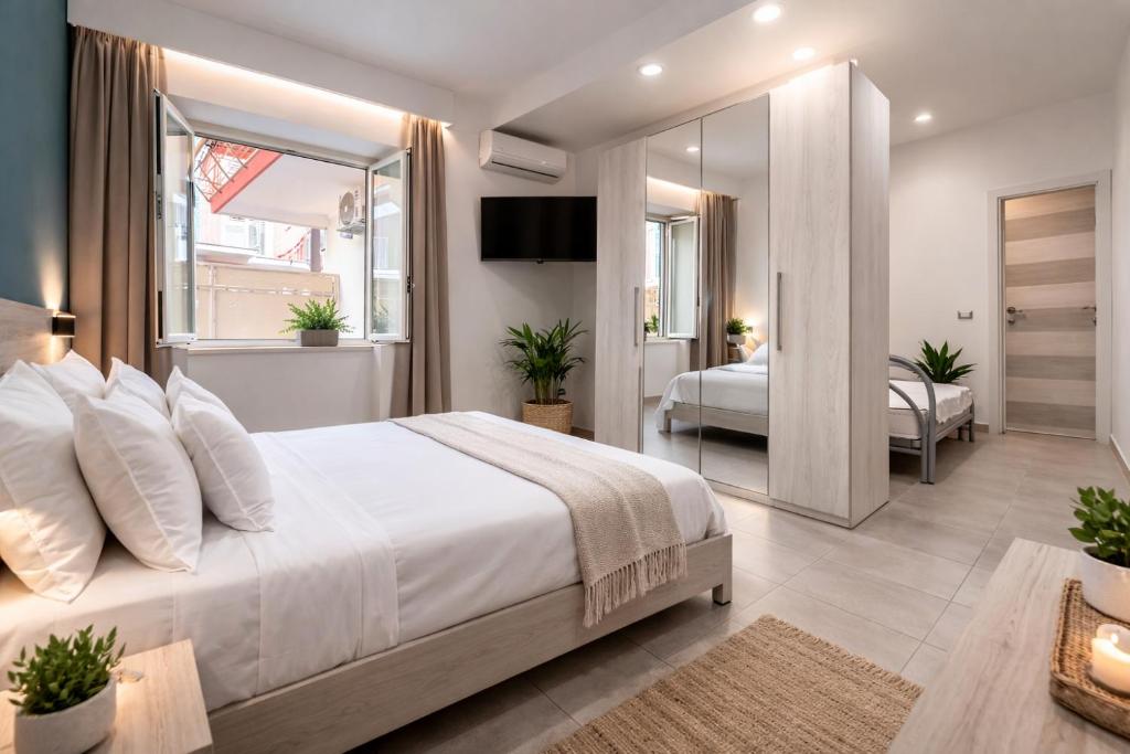 a bedroom with a large white bed and a mirror at The Arco Rooms in Pomigliano dʼArco