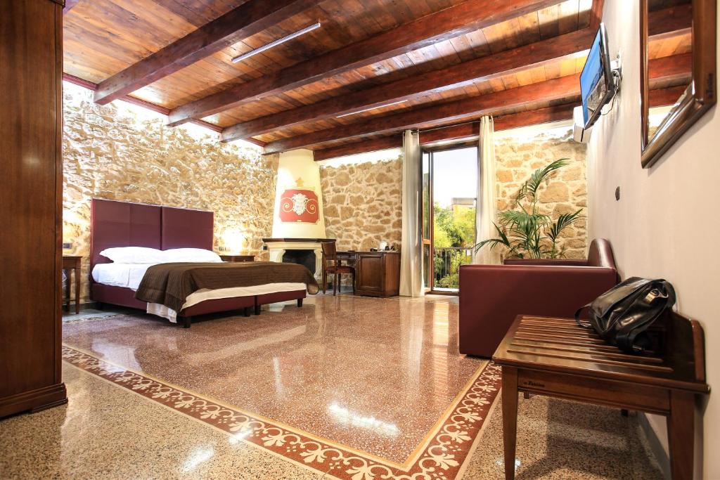 1 dormitorio con 1 cama y 1 sofá en una habitación en Bienestar - Maison de Charme, en Alghero