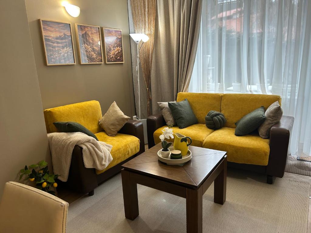 a living room with a yellow couch and a coffee table at Edelweiss Mountain Apartment - Stream Resort Spa & Pool, Pamporovo in Pamporovo