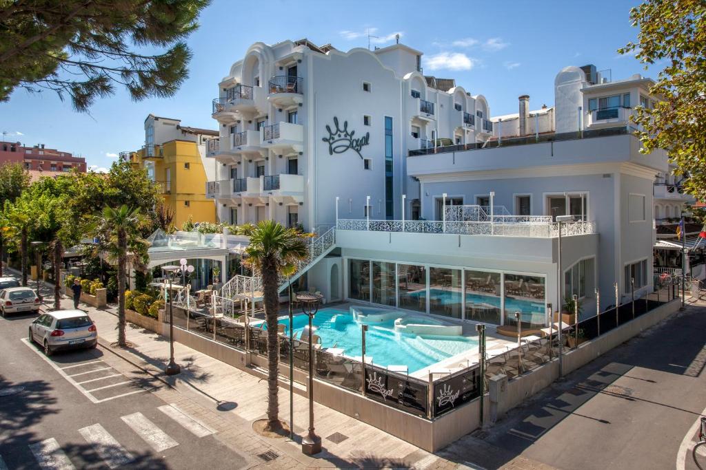 an apartment building with a swimming pool and a parking lot at Royal Boutique Hotel NUOVA GESTIONE in Riccione