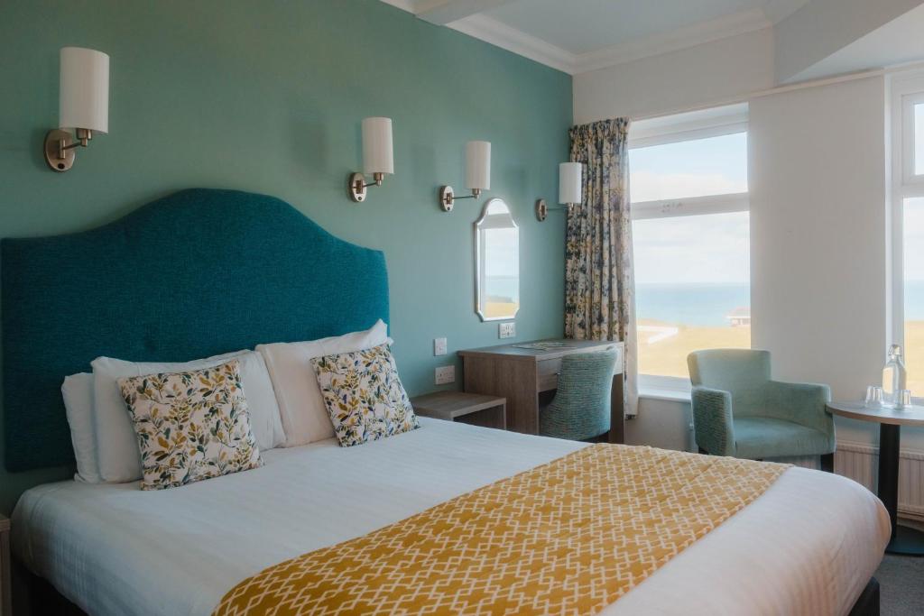 a bedroom with a large bed with a green wall at The Kilbirnie Hotel in Newquay