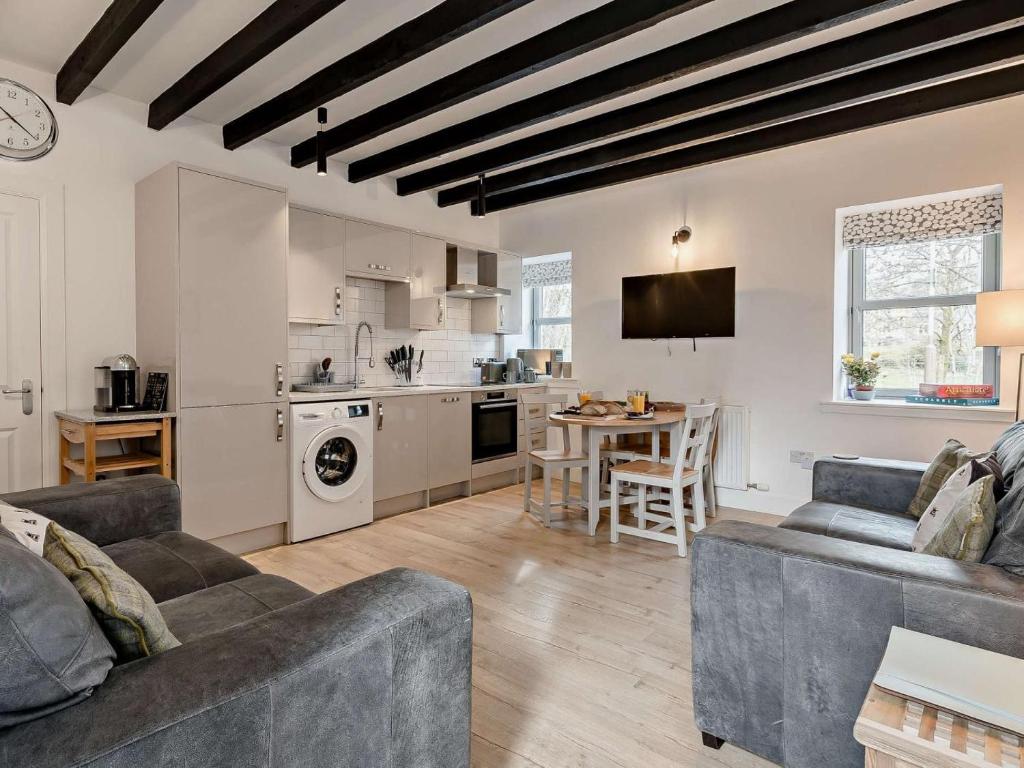 a living room with two couches and a kitchen at 3 Bed in Crieff oc-90794 in Comrie