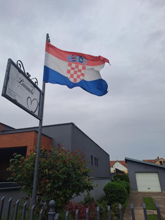 a flag flying in front of a building with a sign at Lavanda in Vukovar