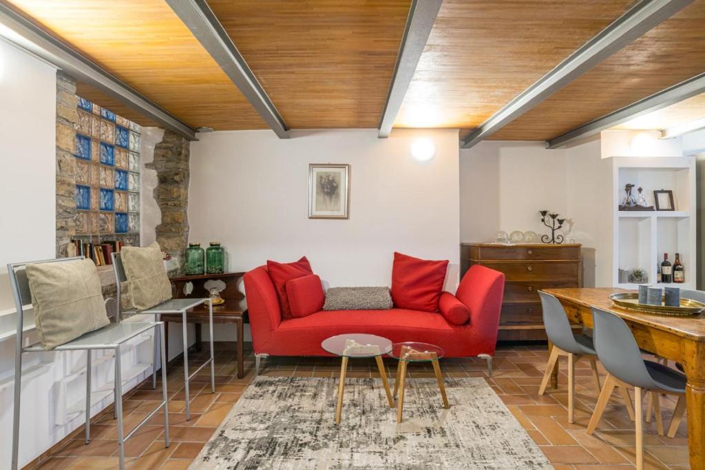 a living room with a red couch and a table at Albavilla Stone Loft in Albavilla