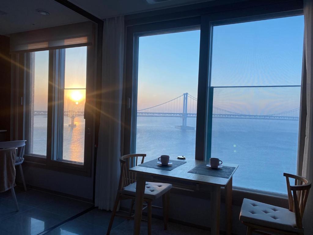 a table and chairs in a room with a view of a bridge at 광안리 오션뷰 in Kwangan-dong