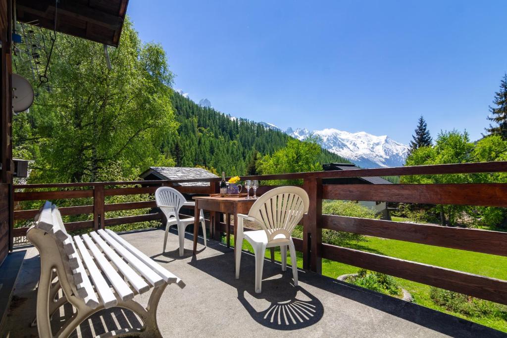 a table and chairs on a balcony with a view at MontBlanc Alpine Ski & Sauna Retreat - Happy Rentals in Le Tour