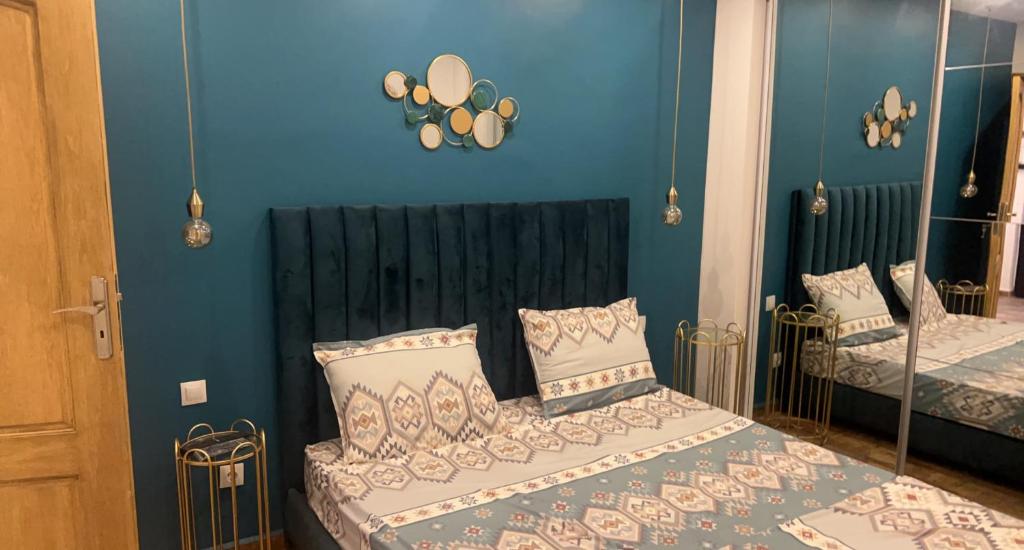a bedroom with two beds with blue walls at Casa hermosa draria in Draria