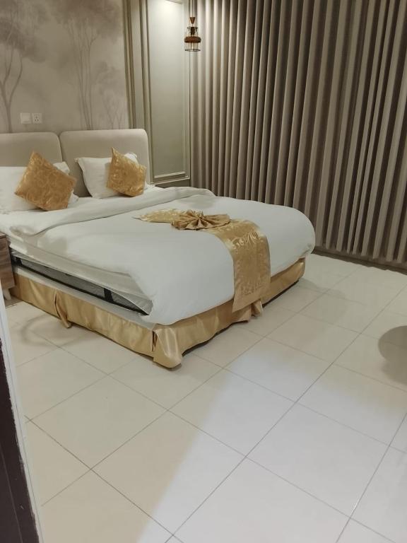 a bedroom with a bed with white sheets and pillows at Golden New Muhayil-نيلولوفر فور in Ḑirs