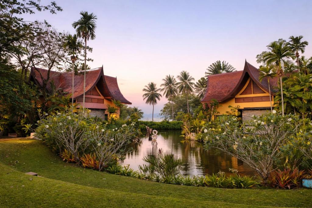 a resort with a pond in front of two buildings at Tha Lane Bay Villas in Tha Lane Bay