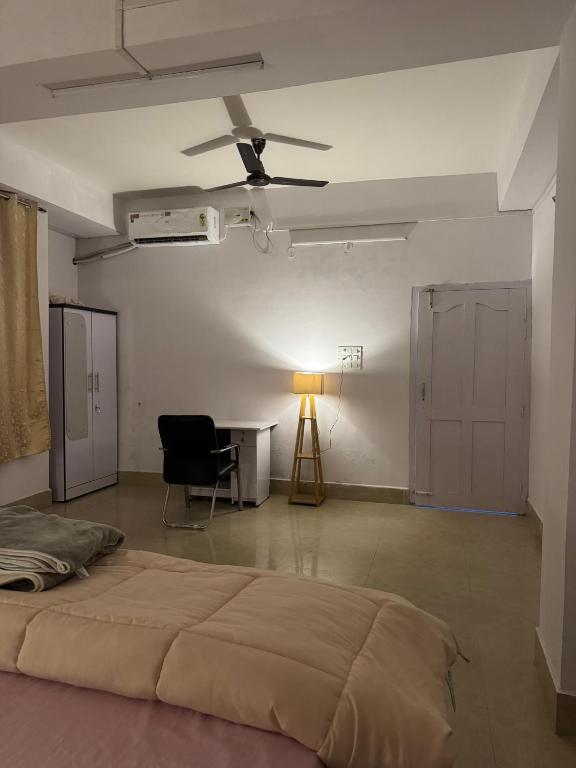 a bedroom with a bed and a table and a ceiling fan at Silo namlo 2BHK in Duimukh