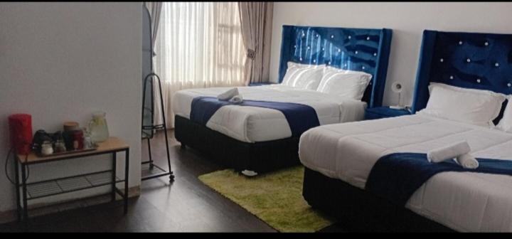a hotel room with two beds and a window at Ayjalon Guest Home in Ludeke
