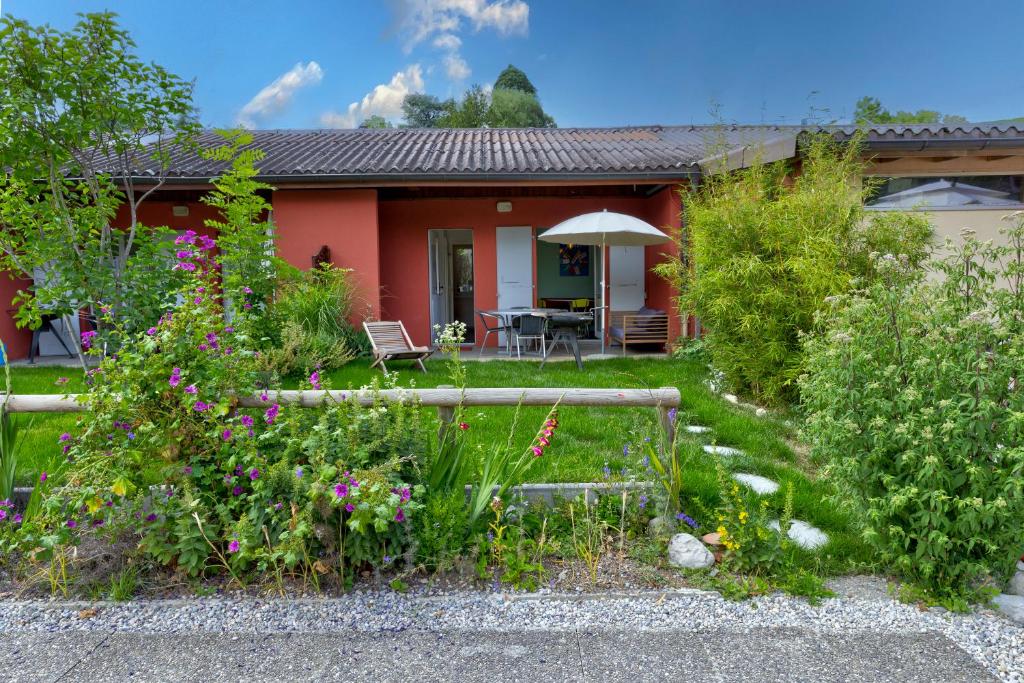 a house with a garden in front of it at Camping "le Pécos" appartement confort 5 personnes in Grandson