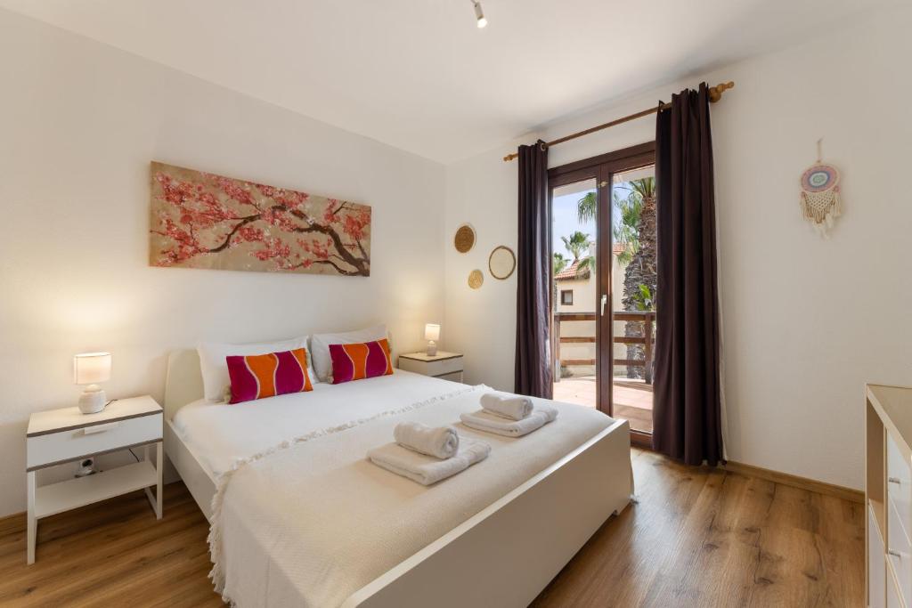 a bedroom with a large white bed with towels on it at Casa del Jable in Parque Holandes