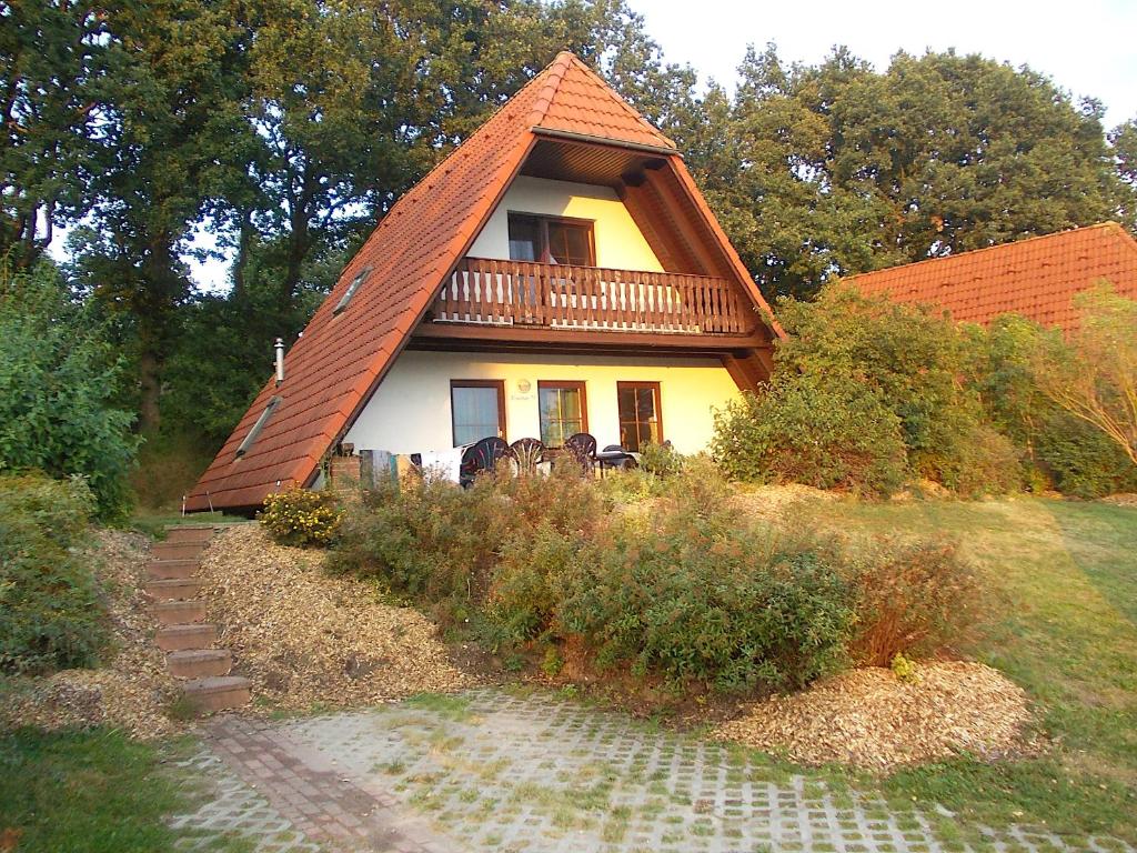 a house with a gambrel roof with a balcony at Finnhaus Lisa in Marlow
