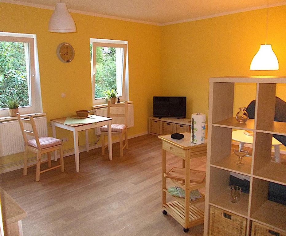a living room with yellow walls and a table and chairs at FeWo Schwalbennest in Marlow