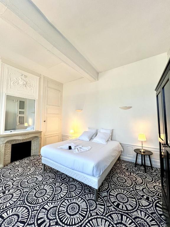 a bedroom with a white bed and a fireplace at Suite Luxe · Cour calme · Chartres centre in Chartres