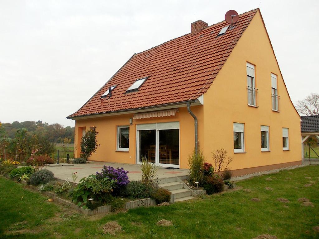 a small yellow house with a red roof at Ferienhaus "Am Wald" in Behrenwalde
