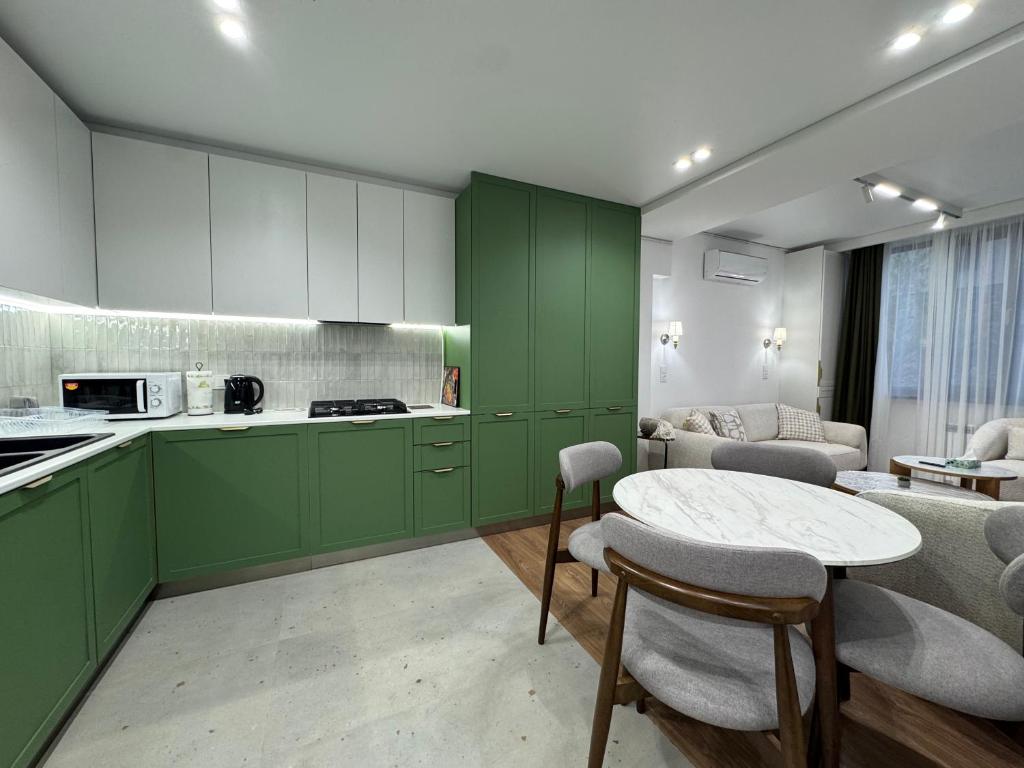 a kitchen with green cabinets and a table and chairs at Modern apartment in Yerevan